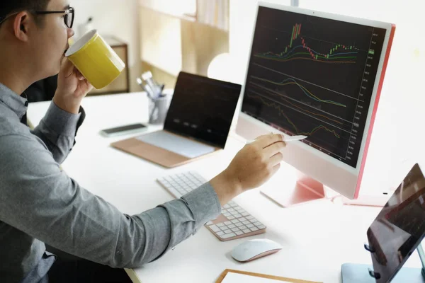 投資の専門家は利益のための株式市場を分析するために彼らのコンピュータモニターでペンを指す — ストック写真