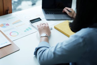 Muhasebeciler ve Asyalı denetçiler vergi bütçelerini gözden geçirmek için hesap makineleri ve bilgisayarlar kullanarak vergi dairesine bilgi gönderiyorlar.