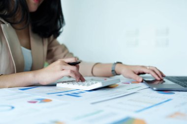 Muhasebeciler ve Asyalı denetçiler vergi bütçelerini gözden geçirmek için hesap makineleri ve bilgisayarlar kullanarak vergi dairesine bilgi gönderiyorlar.