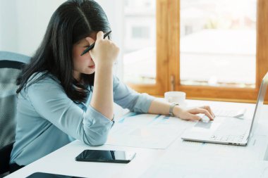 Sme işletme sahibi, bilgisayar ve finansal tabloları kullanan kadın, piyasanın genişletilmesi konusunda endişeli ifade, iş dünyasına yatırım yapma yeteneğini artırmak için.