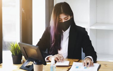 Business woman using calculator to review balance sheet annual using document and laptop computer to calculating budget. audit and Check integrity before investment concept