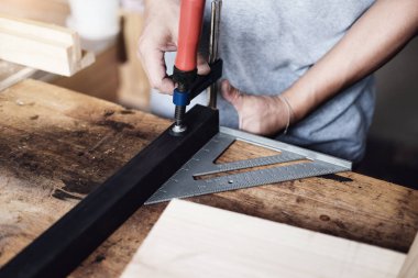Woodworking operators are decorating pieces of wood to assemble and build wooden tables for customers