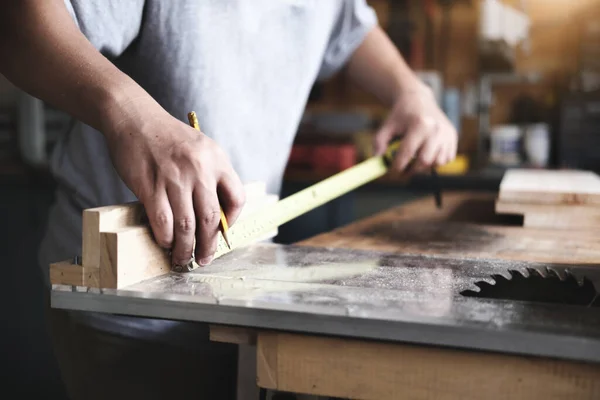 stock image do-it-yourself concept Craftsmen use a tape measure to assemble wooden pieces to make wooden tables for customers