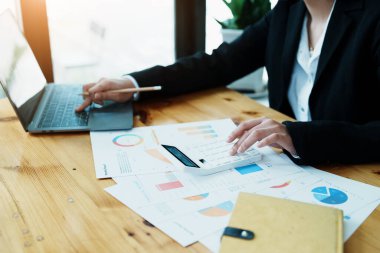 Muhasebeciler ve Asyalı denetçiler vergi bütçelerini gözden geçirmek için hesap makineleri ve bilgisayarlar kullanarak vergi dairesine bilgi gönderiyorlar.