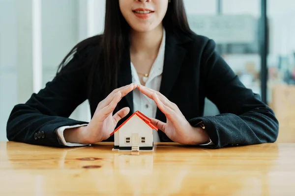 portrait of an asian woman, Agent, buy and sell land, property tax, show the concept of protecting the house to insure the risk of damage to the home.