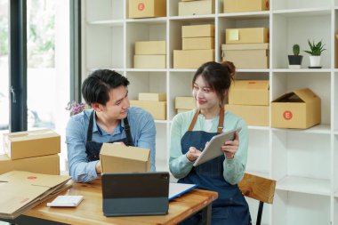 Küçük bir girişimin portresi ve KME sahibi, siparişleri kontrol eden Asyalı bir erkek ve kadın girişimci, müşteriler için paketleme, serbest meslek sahibi, serbest meslek sahibi, çevrimiçi satış.