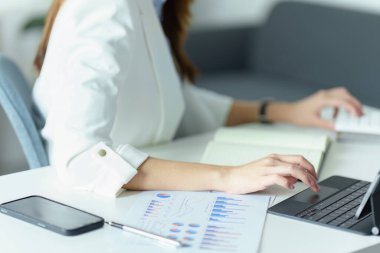 Tablet bilgisayar ve hesap makinesi kullanan Asyalı işkadını veya işyeri sahibi.