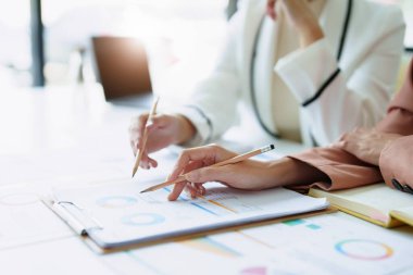 Satışları planlamak için ürün belgelerini kullanan bir pazarlama çalışanı ve bir satıcının portresi..