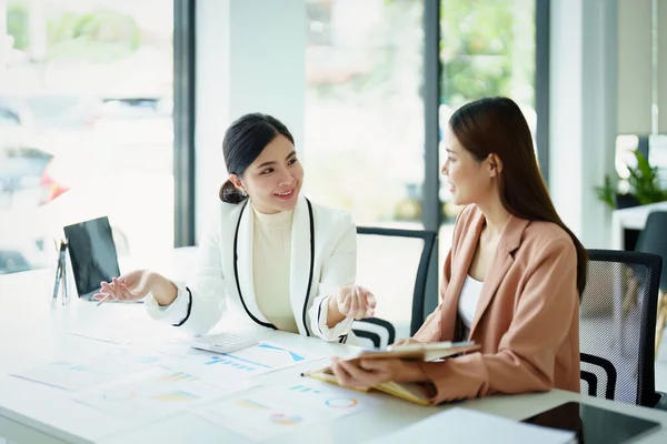 Satışları planlamak için ürün belgelerini kullanan bir pazarlama çalışanı ve bir satıcının portresi..