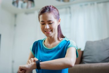 Health care, heart rate monitor, portrait of Asian beautiful woman using smart watch to select health programs such as yoga, cardio exercises, breathing meditation. to prepare before the activity.