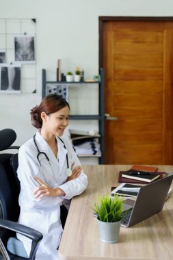 Bilgisayar kullanan Asyalı bir doktorun portresi.