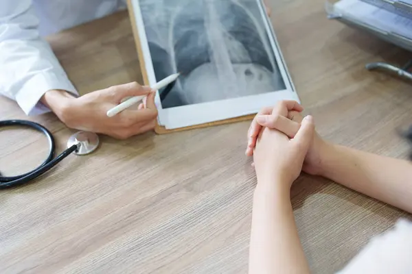 Μια Ασιάτισσα Γιατρός Δείχνει Μια Ακτινογραφία Ασθενούς Για Εξηγήσει Διαδικασία — Φωτογραφία Αρχείου