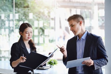 Konsültasyonda, kadın işadamlarına kar yapılandırmasını açıklamak için tablet kullanan bir erkek danışman