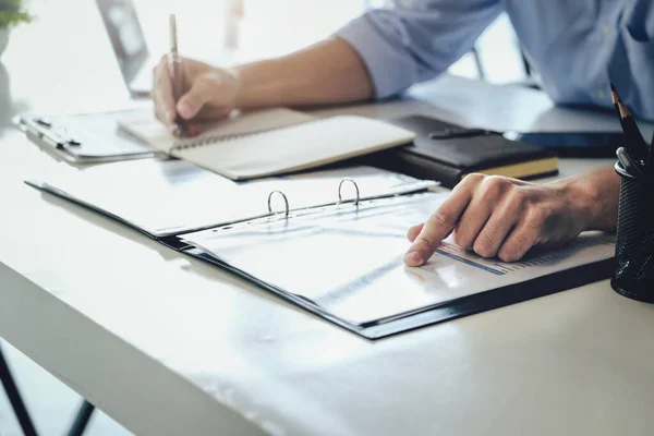 stock image Examining the financial budget, a male auditor is pointing to a file to summarize the companys irregular financial budget