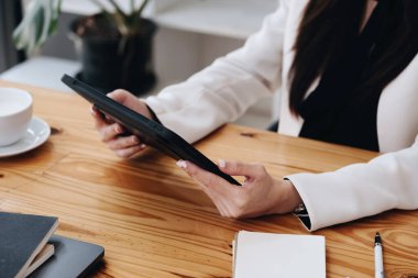 Veri analizi, pazarlama ve muhasebe için tablet bilgisayar kullanan bir iş kadınının portresi.