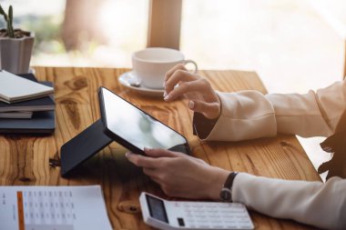 Veri analizi, pazarlama ve muhasebe için tablet bilgisayar kullanan bir iş kadınının portresi.