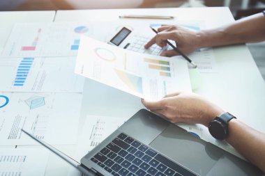 İşadamı elleri, şirket hesaplarını, gelirlerini ve bütçesini kontrol etmek için hesap makinesi kullanıyor. aylık giderlerin hesaplanması, bütçe yönetimi, kağıtlar, kredi belgeleri, faturalar.