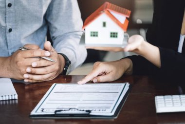 Konut kredisi, yeniden finansman, ev ve arazi alımı, kiralık konaklama, kadın emlakçı ya da banka çalışanı erkek bir müşteriyle konut satın almak için sözleşme ya da anlaşma yaptığına işaret ediyor