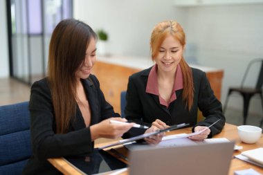 Asyalı bir iş kadını danışmanının portresi, ofis odasındaki müşterilerin ihtiyaçlarını karşılamak için bir pazarlama planı başlatın.