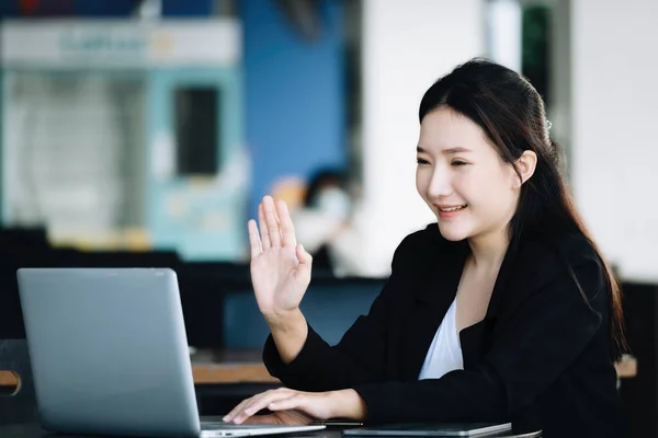 아시아 직원이나 사업가가 회의를 노트북 컴퓨터를 사용하여 동료에게 미소를 흔드는 — 스톡 사진
