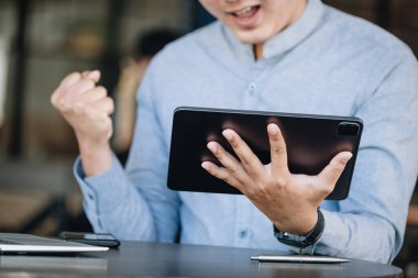 Hisse senedi kar analizi konsepti, risk yönetimi, finansal özgürlük, tablet kullanan erkek borsacı, İnternet medyası kullanarak hisse alıp satmaktan keyif aldığını ifade ediyor