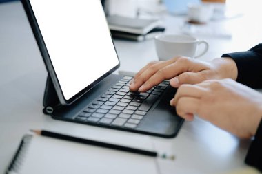 İş yerinde ev tabletinden iş kullanan genç adam, bilgisayar ekranındaki boşluk metin ekleyebilir