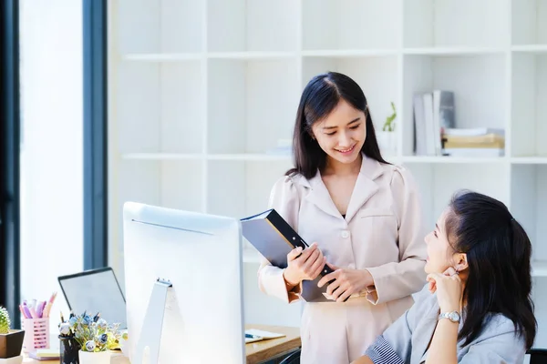 数据分析 投资结论 女雇员和亚洲同事讨论其所服务公司的财务报表和投资风险 — 图库照片