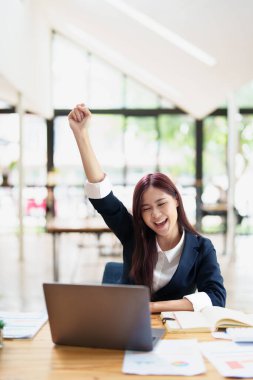 Neşeli Asyalı zaferini internette dizüstü bilgisayarıyla kutluyor..