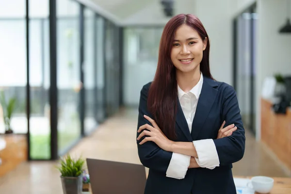 Portrait of a business woman standing with her arms crossed.