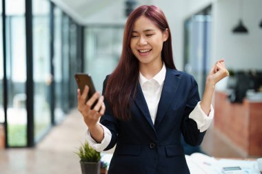 İş adamları ortaklarıyla iletişim kurmak için akıllı telefonu kullanır, başarı kavramı.