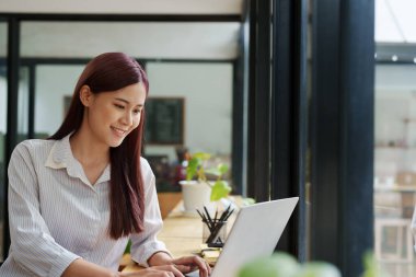 Finansal tablolarda çalışmak için bilgisayar kullanan bir iş kadınının portresi..