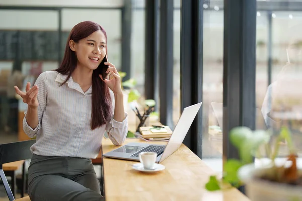 stock image Asian businesswoman using the phone to contact a business partner.