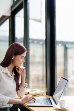 Finansal tablolarda çalışmak için bilgisayar kullanan bir iş kadınının portresi..