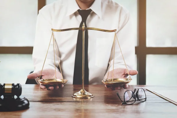 stock image A judge or lawyer holds a scale of justice.