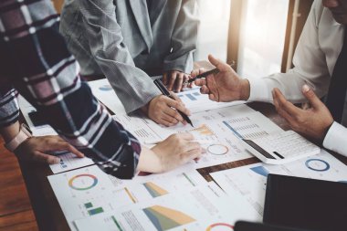 Yatırım risklerini azaltmayı planlayan bir grup iş adamının ortaklarla birlikte çalıştığı imajı, toplantılarda kârlı ve hedeflenmiş müşteri ihtiyaçlarını analiz etmek üzere pazarlama stratejilerini ayarlıyor.