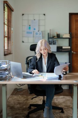 Muhasebeciler ve Asyalı denetçiler vergi bütçelerini gözden geçirmek için hesap makineleri ve bilgisayarlar kullanarak vergi dairesine bilgi gönderiyorlar.