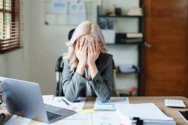 Sme işletme sahibi, bilgisayar ve finansal tabloları kullanan kadın, piyasanın genişletilmesi konusunda endişeli ifade, iş dünyasına yatırım yapma yeteneğini artırmak için.