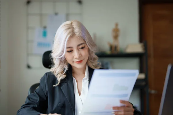 financial, Planning, Marketing and Accounting, portrait of Asian employee checking financial statements using documents and calculators at work..