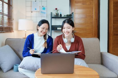 lgbtq, lgbt concept, homosexuality, portrait of two asian women posing happy together and loving each other while playing computer laptop with notebook for learning online.