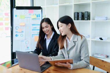 Negotiation, Analysis, Discussion, Asian young economist and marketer using computer to plan investments and financial to prevent risks and losses for the company.