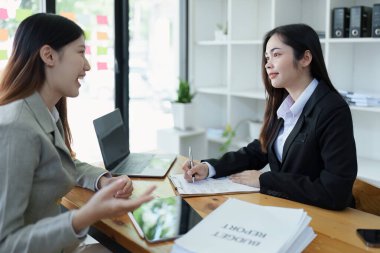 Şirket toplantıları sırasında planlanan yatırım projeleriyle ilgili iş raporlarını analiz eden mali analistler pazarlama planı, bilgisayarlar ve hesap makineleriyle başarılı bir takım çalışması sergilediler..