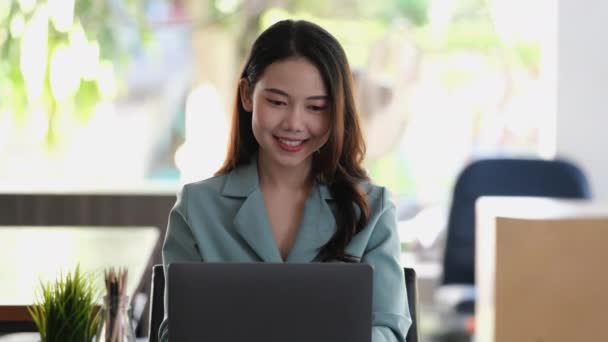 パソコンを使っている女性社員が 会社の売り上げ目標に満足している笑顔を見せてくれる — ストック動画