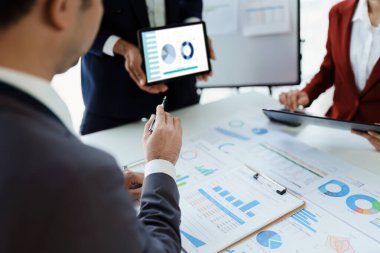 Toplantı odasındaki mali raporda durumu analiz etmek ve tartışmak için takım iş danışmanı toplantısı. Tablet, hesap makinesi, doküman ve bilgisayar kullanılıyor.