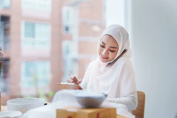 Beautiful Muslim woman selling online at home, business owner, business sme concepts.