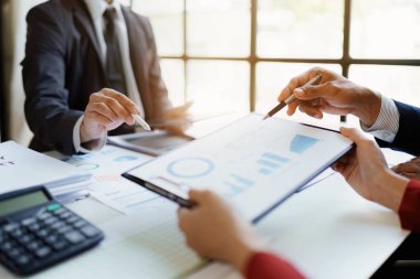 Toplantı odasındaki mali raporda durumu analiz etmek ve tartışmak için takım iş danışmanı toplantısı. Belgeler, hesap makinesi ve bilgisayar bilgisayarı kullanılıyor.