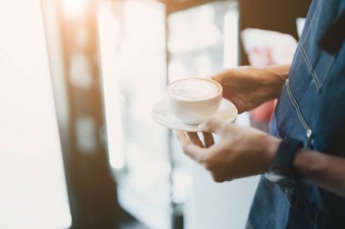 Asyalı erkek barista müşteriler için kahve yapıyor..