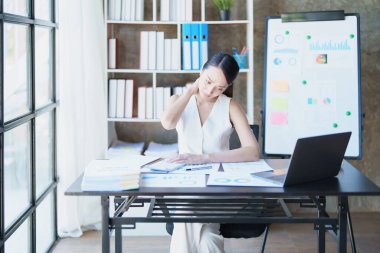 Uzun süre oturmaktan omuz ağrısı çeken genç Asyalı kadın temsilcinin portresi..