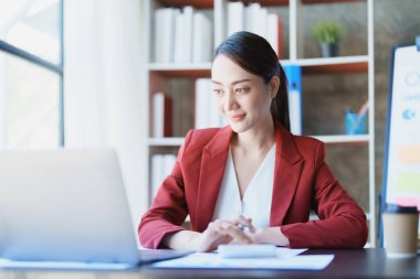 Muhasebeciler ve Asyalı denetçiler vergi bütçelerini gözden geçirmek için hesap makineleri ve bilgisayarlar kullanarak vergi dairesine bilgi gönderiyorlar.