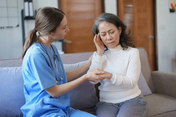Portrait of a female doctor talking to an elderly patient showing headache