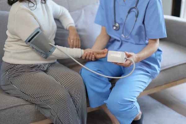 stock image Portrait of female doctor measuring patients blood pressure before treatment